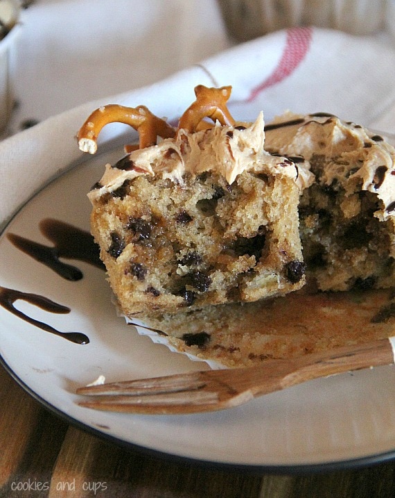 Chocolate chip banana cupcake with pretzel garnish cut in half on a plate