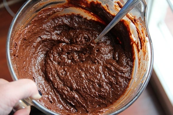 Top view of pumpkin brownie batter in a glass mixing bowl with a spoon