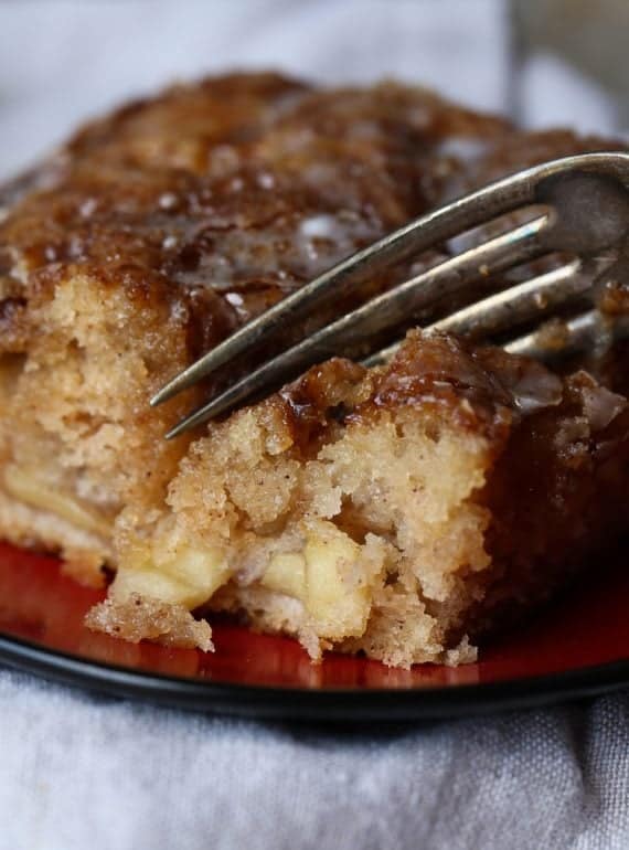 Fork cutting into apple fritter cake