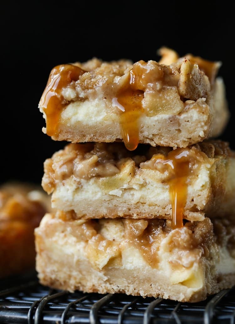 Barras de pastel de queso con manzana y caramelo apiladas una encima de la otra.