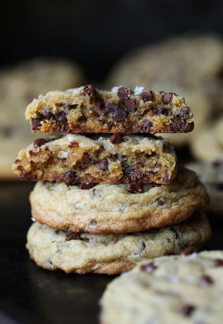 Stack of homemade chocolate chip cookies with the top cookie broken in half.