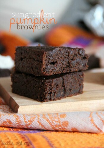 Two pumpkin brownies stacked on a wooden board