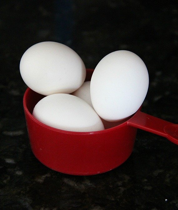 Four eggs in a red measuring cup