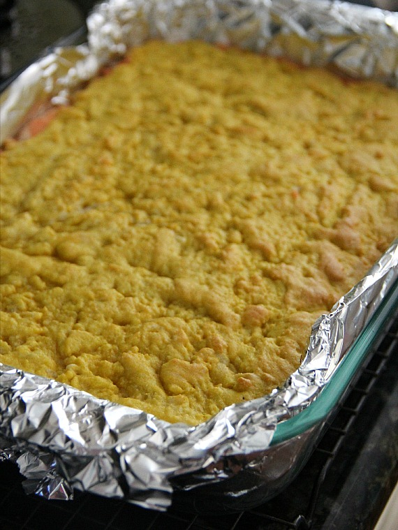 A baked pan of bars with a yellow layer over orange layer