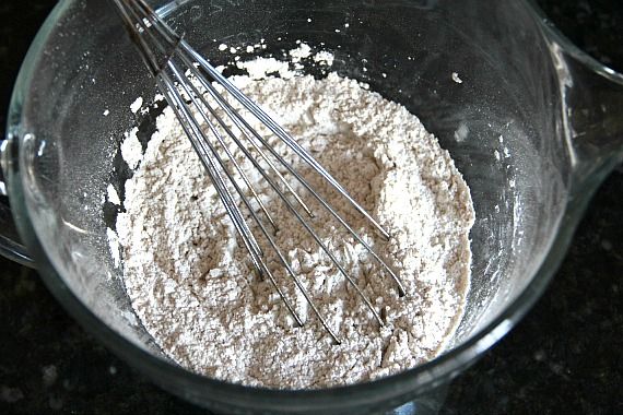 Top view of dry ingredients in a mixing bowl with a whisk