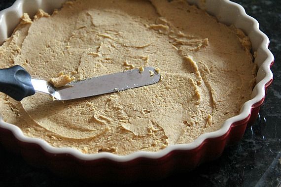 Pumpkin shortbread batter being spread in a tart pan