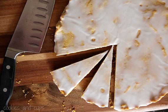 Top view of a round glazed pumpkin shortbread pie cut into wedges