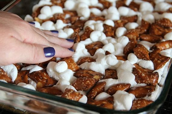Pretzels being pressed into bar cookies with marshmallows