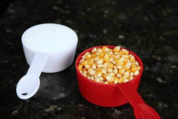 Popcorn kernels and sugar in measuring cups