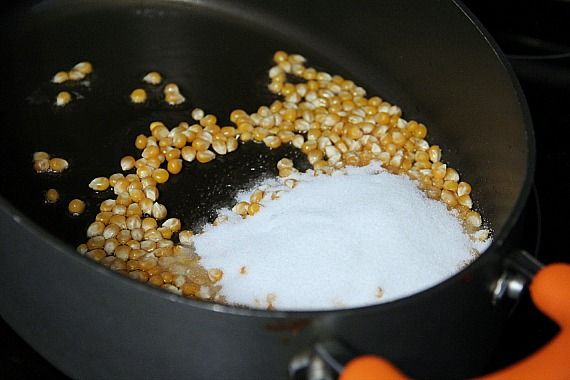 Popcorn kernels and sugar in a pan with oil