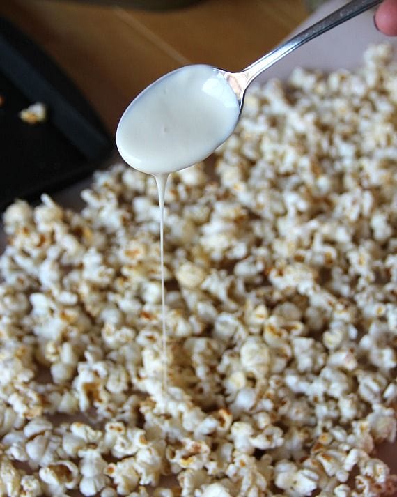 White chocolate being drizzled over kettle corn