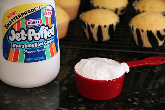 A jar of Jet Puffed marshmallow creme with some in a measuring cup