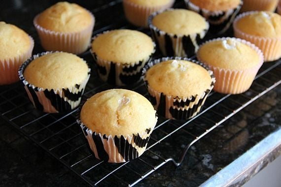 Vanilla cupcakes filled with marshmallow creme on a cooling rack