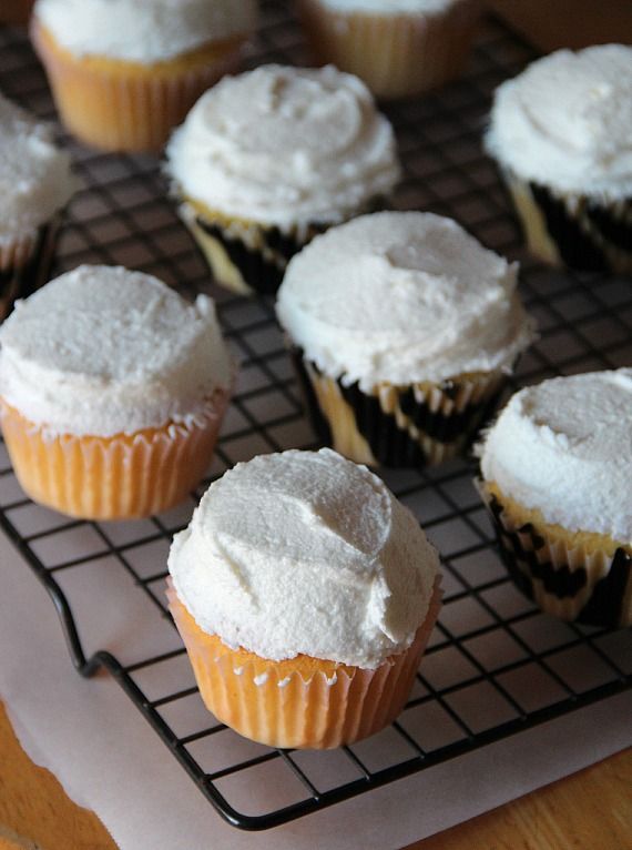 Frosted vanilla cupcakes on a cooling rack