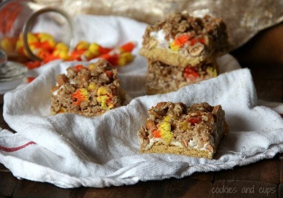 Layered scarecrow bars with crust, marshmallow, candy corn and cereal on a cloth