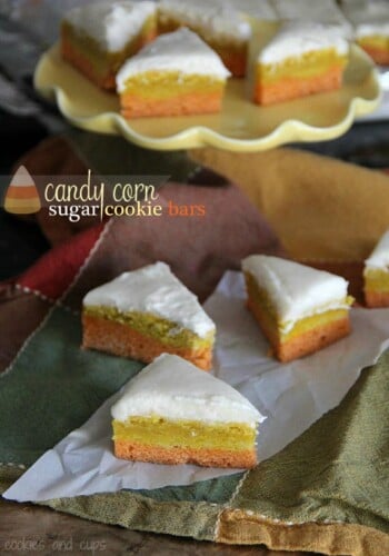 Three wedges of Candy Corn Sugar Cookie bars on parchment paper