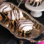 Overhead view of three zebra cake cupcakes on a silver tray