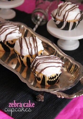 Overhead view of three zebra cake cupcakes on a silver tray