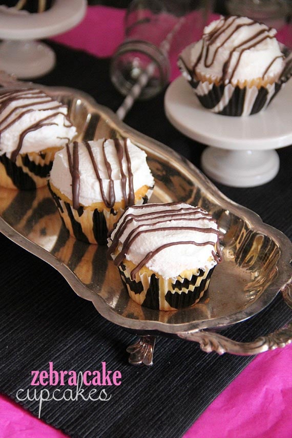 Overhead view of three zebra cake cupcakes on a silver tray