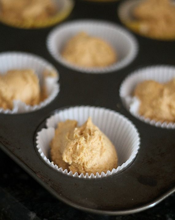 A muffin tin filled with muffin liners and unbaked cupcake dough