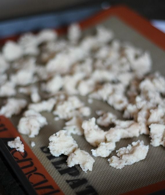 Unbaked streusel topping on a silicone mat on a baking sheet