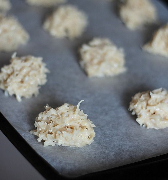 Scoops of coconut macaroon batter on a parchment-lined baking sheet