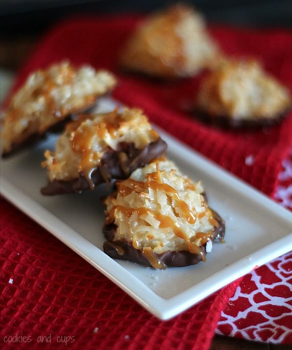 Three chocolate dipped coconut macaroons with caramel drizzle on a plate