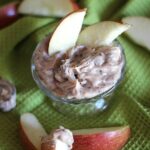 Overhead view of Caramel Apple Dip in a glass with two apple slices sticking out