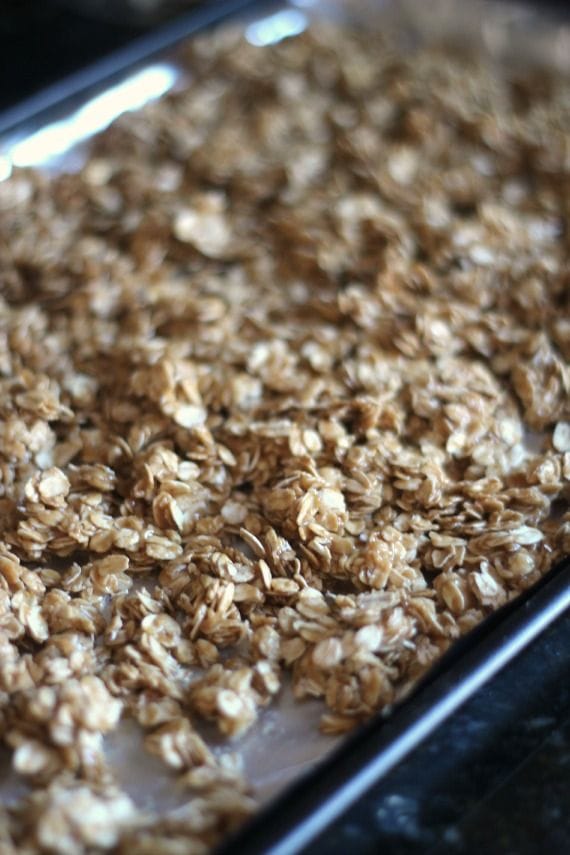 Peanut butter coated oats on a baking sheet