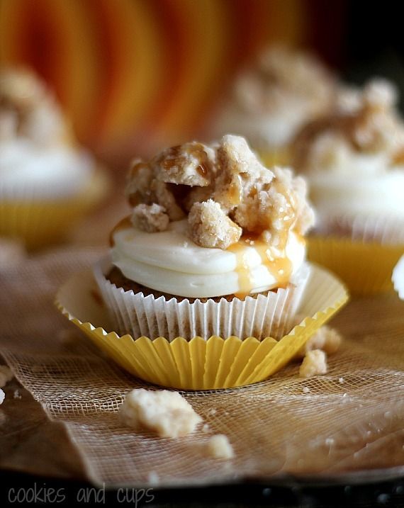 Pumpkin cupcake with a swirl of cream cheese frosting and streusel on top