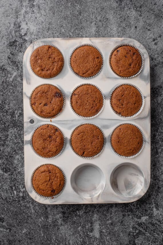 Baked gingerbread cupcakes in a cupcake pan.