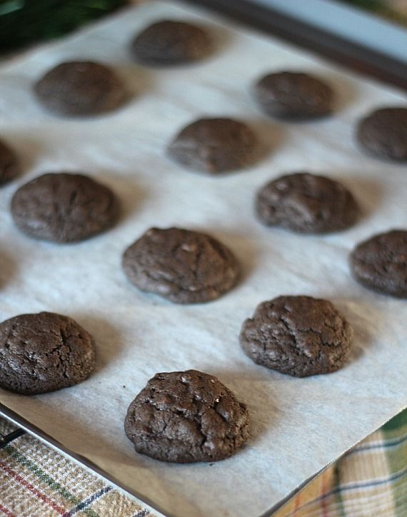 Baked chocolate cookies on a parchment-lined baking sheet