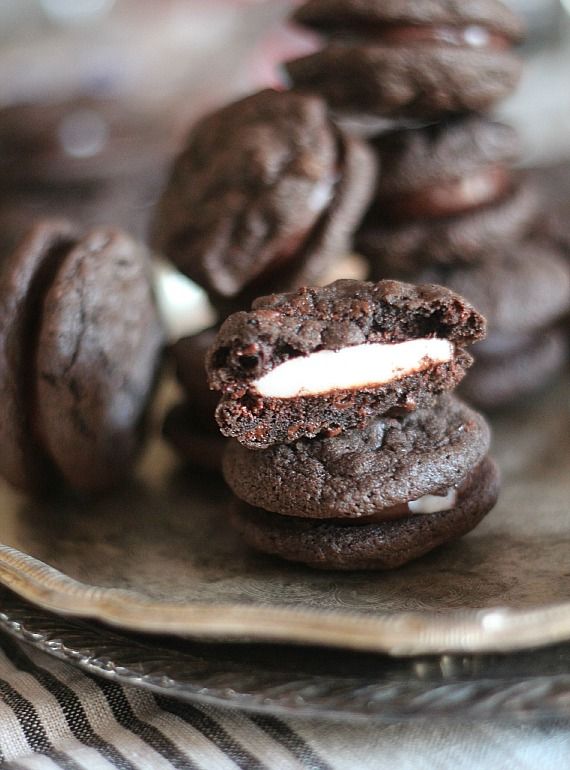 Peppermint patty sandwich cookies on a plate with one cut in half