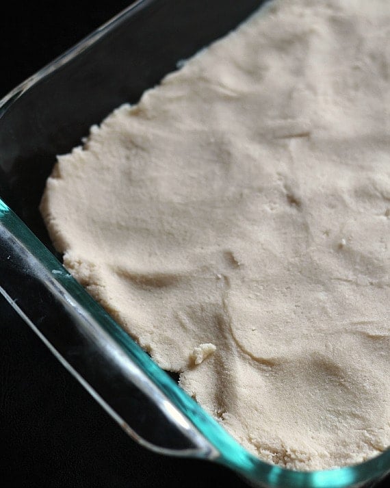 Toffee cheesecake bar crust spread in a rectangular baking dish