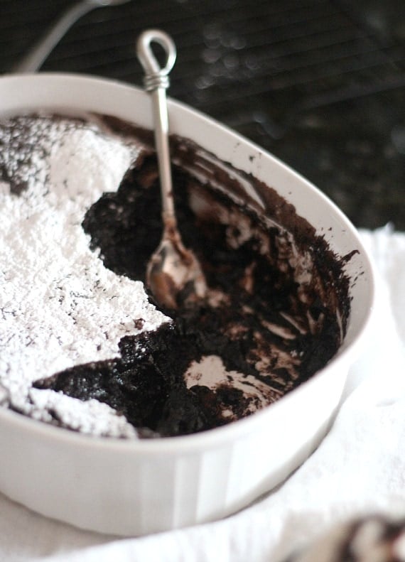 Brownie pudding in a baking dish topped with powdered sugar