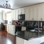 A remodeled kitchen with white cabinets