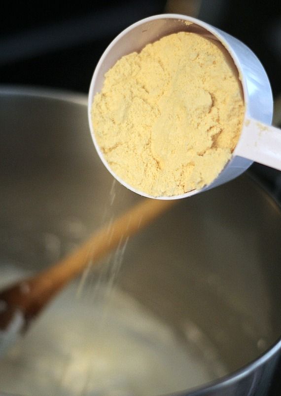 Malted milk powder being added to a pan of melted marshmallow mixture