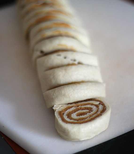 Slices of rolled-up crescent roll dough with Biscoff spread