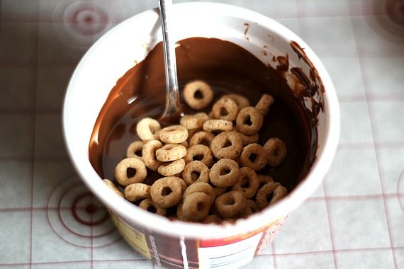 Cheerios in a cup of melted chocolate