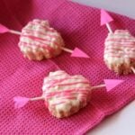 Valentine's Heart Krispie Treats with cupid arrows on a pink napkin