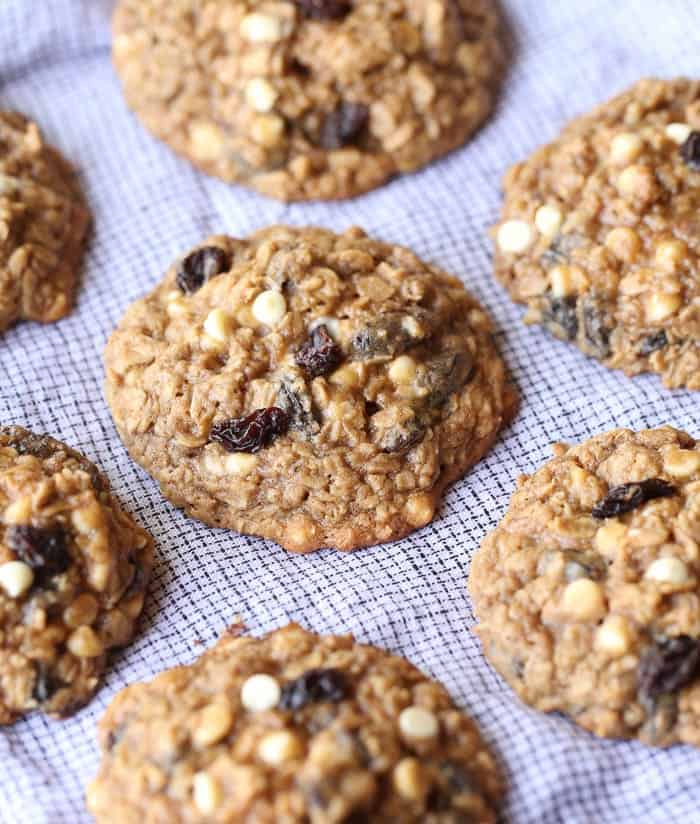 Rows of oatmeal raisin cookies on a white cloth.