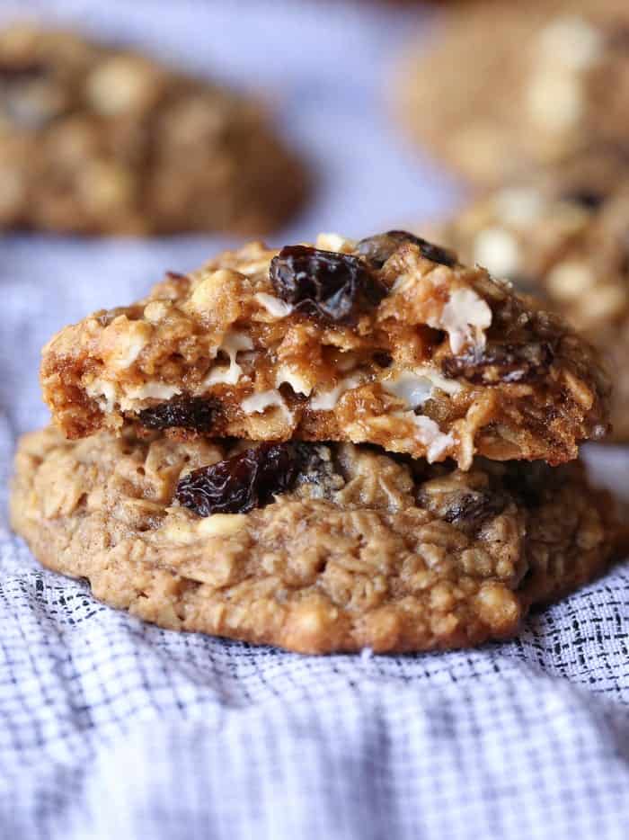 Two oatmeal raisin cookies stacked, with a bite missing from the top one.