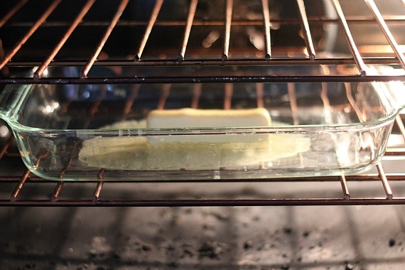 A stick of butter melting in a baking dish in the oven