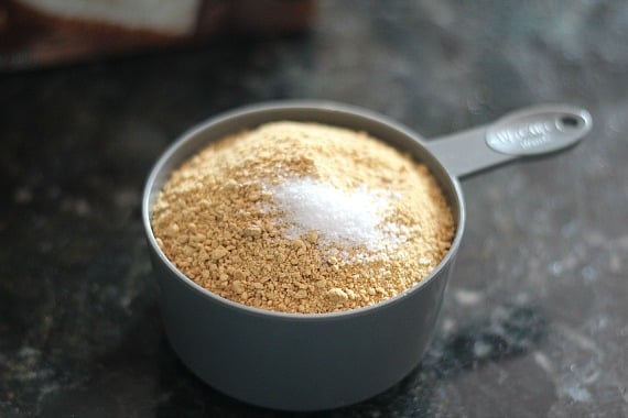 Graham cracker crumbs with a pinch of salt in a measuring cup