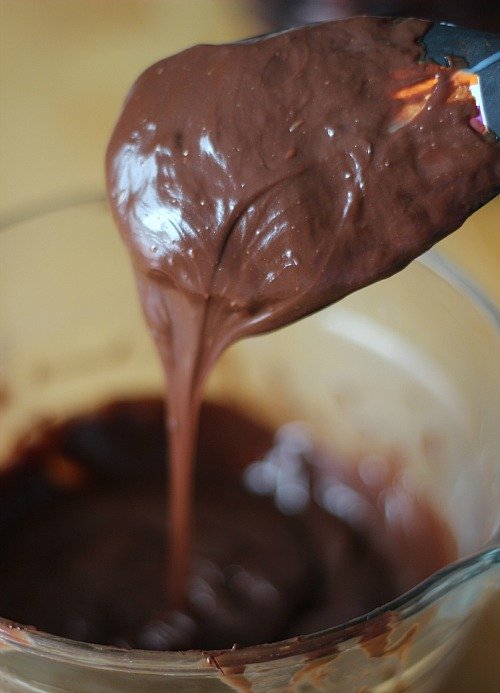 Chocolate batter on a spatula in a mixing bowl
