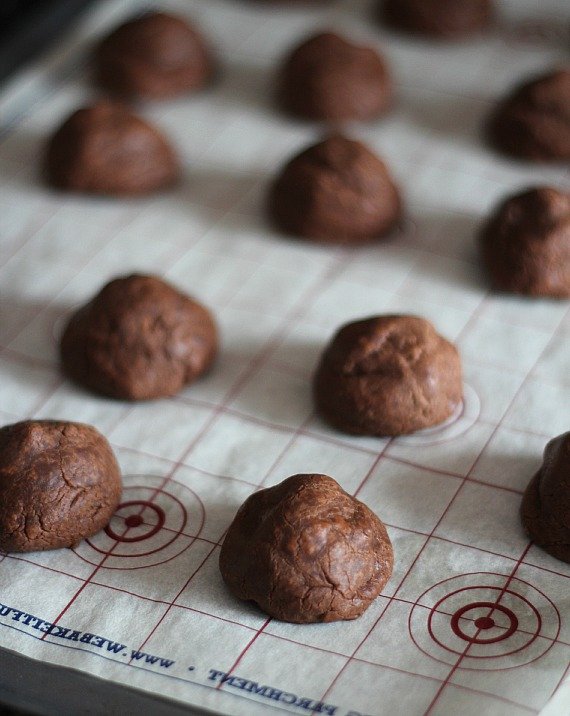 Baked round chocolate cookies on a baking mat