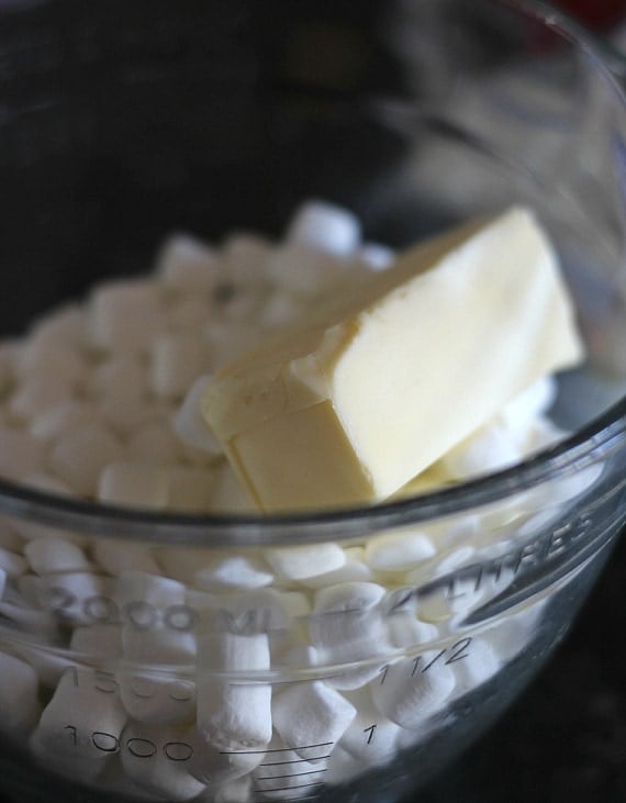Mini marshmallows and a stick of butter in a glass mixing bowl