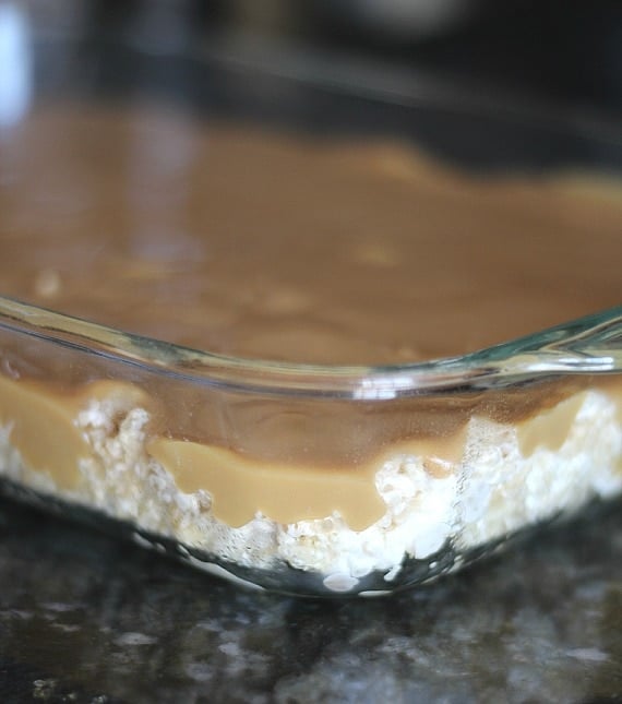 Caramel sauce over rice krispie treats in a pan