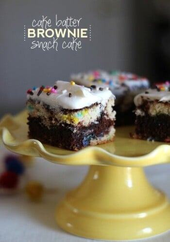 Squares of cake batter brownie snack cake on a yellow cake stand