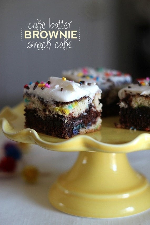 Squares of cake batter brownie snack cake on a yellow cake stand